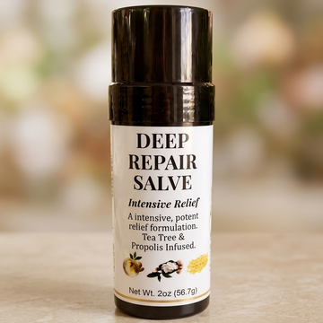 A 2-ounce black twist-up tube of Deep Repair Salve resting on a light-colored surface against a soft, blurred background. The white label features bold black text reading "DEEP REPAIR SALVE," with subtext that says "Intensive Relief," "A intensive, potent relief formulation," and "Tea Tree & Propolis Infused," accompanied by small graphics of botanical ingredients near the bottom.
